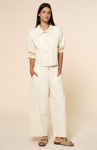 Woman wearing a cream-colored outfit on a beige background